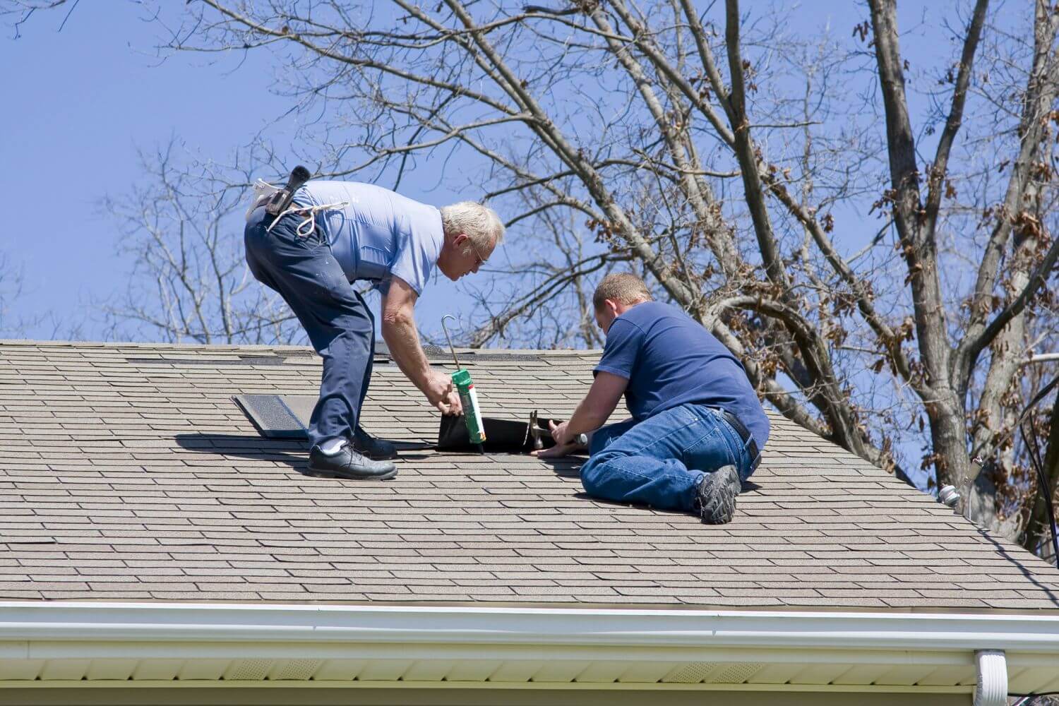 Professional roofer installing tiles on a residential roof